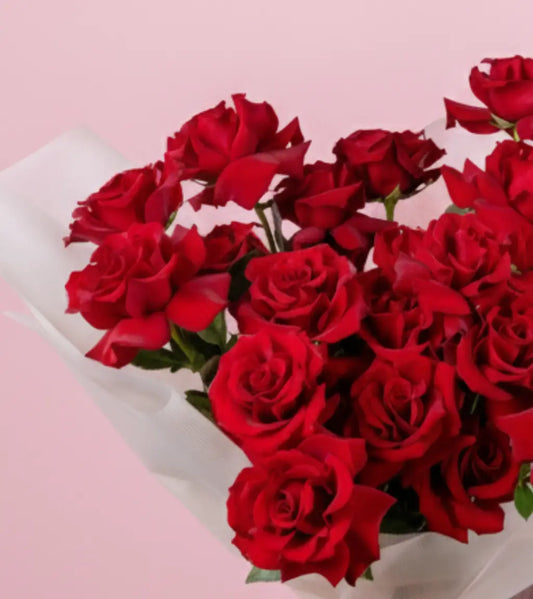 Close‑up of Ever Red rose petals and pistachio greenery in the Crimson Devotion bouquet