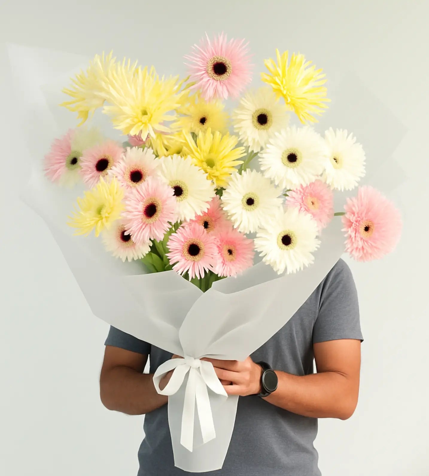Luxury Golden Dawn Bouquet of gerberas held by model in grey clothing, perfect for gift delivery in the UAE.