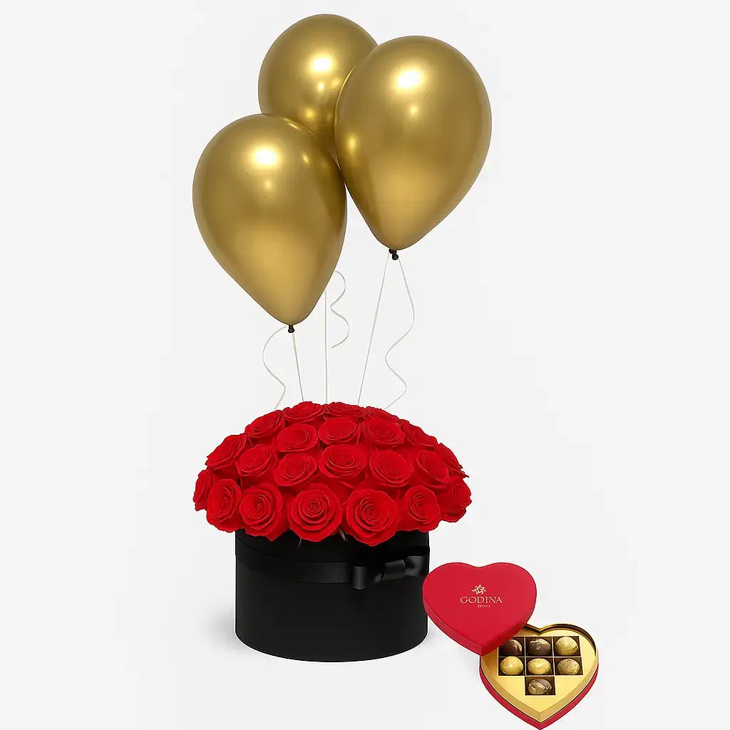 Luxury black box with red roses, gold balloons, and heart-shaped chocolates – Midnight Romance gift box available for same-day delivery in Dubai.