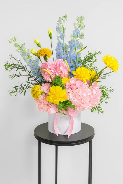 Amara Blossom luxury flower box with fresh pink and yellow flowers in a white hatbox, available for delivery across UAE