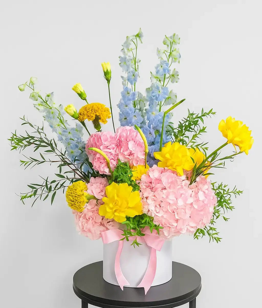 Amara Blossom luxury flower box with fresh pink and yellow flowers in a white hatbox, available for delivery in Dubai and across UAE