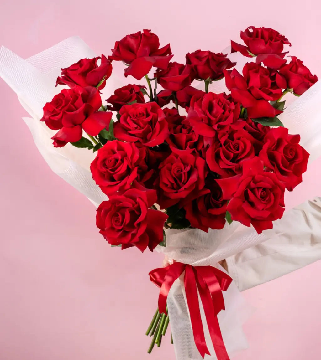 Crimson Devotion hand‑tied wrap with red ribbon and lush pistachio foliage