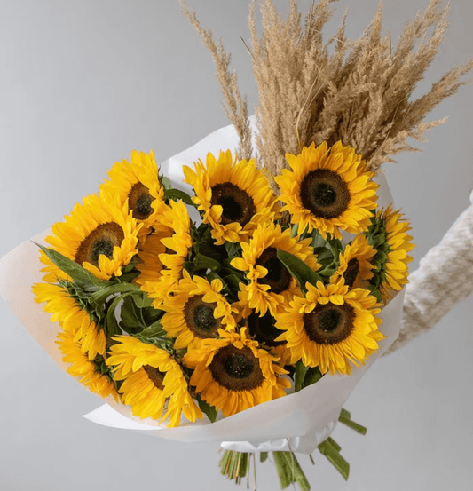Golden Hour Blooms sunflower bouquet with pampas grass wrapped in white paper, available for same-day flower delivery in Dubai