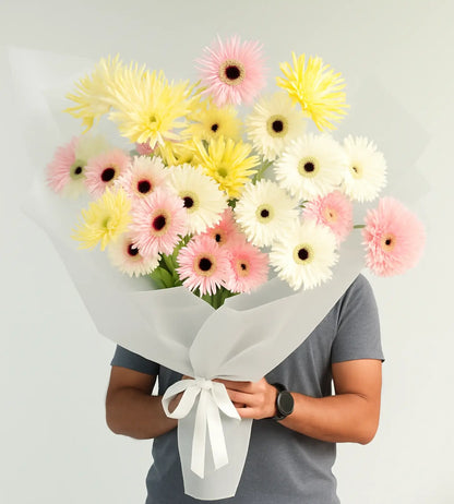 Luxury Golden Dawn Bouquet of gerberas held by model in grey clothing, perfect for gift delivery in the UAE.