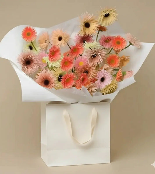 Pastel Breeze bouquet with bright gerbera daisies in pink, orange, and yellow, arranged in a white paper wrap and kraft box – same-day flower delivery in Dubai.