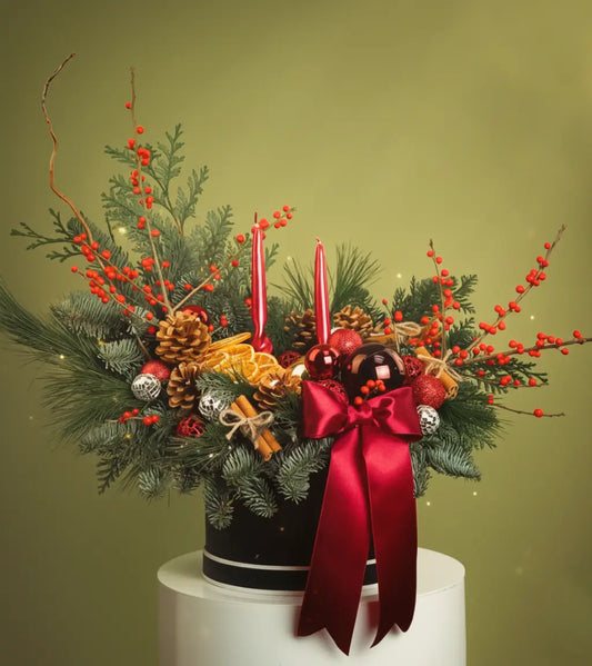Red Layali Hatbox luxury Christmas arrangement with two red candles, red bow ribbon, evergreens and berries for Dubai delivery