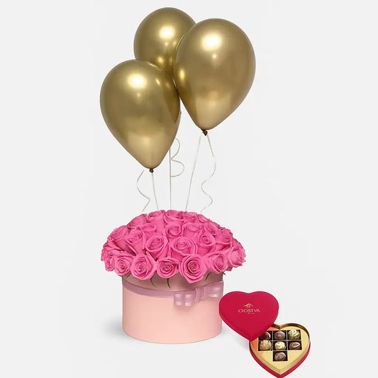 Luxury flower gift box with pink roses, gold balloons, and heart-shaped Godiva chocolates – perfect for romantic surprises and flower delivery in Dubai.